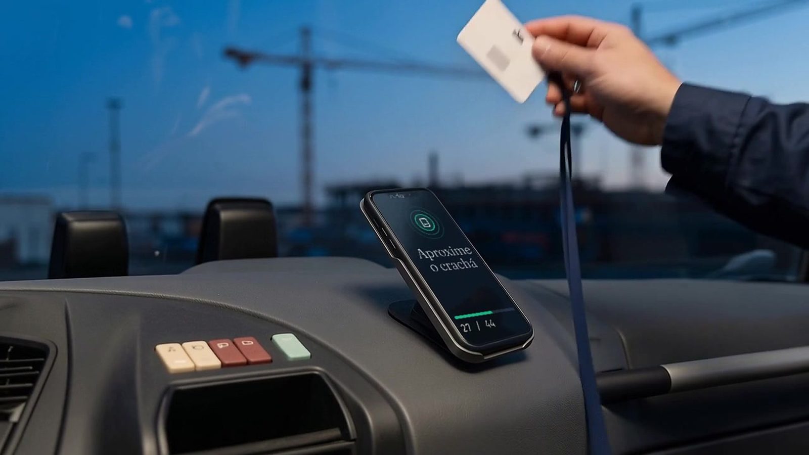 Colaborador aproxima o crachá do smartphone inclinado no painel, que mostra Aproxime o crachá